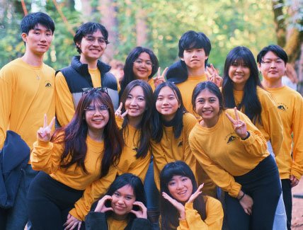 large group of smiling students in gold shirts