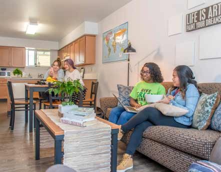 female students relaxing in apartment living room